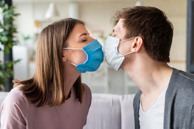 Front view of couple using medical mask