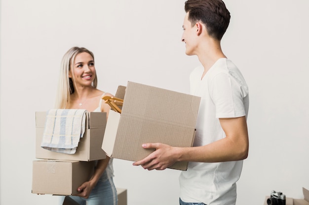 Front view couple with boxes looking at each other