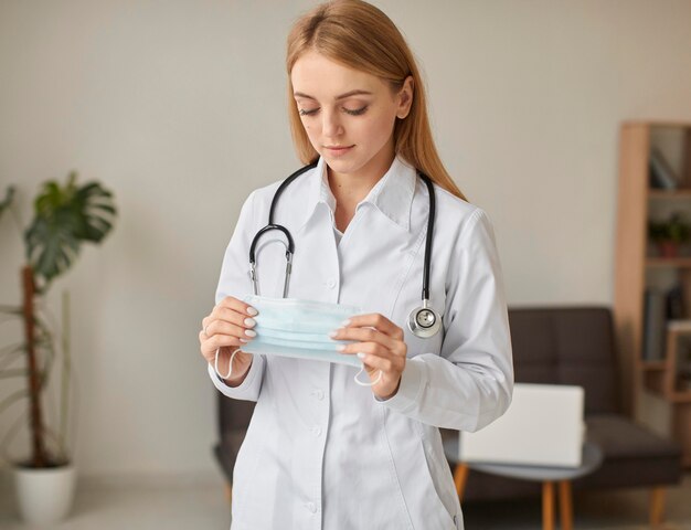 Front view of covid recovery center female doctor holding medical mask