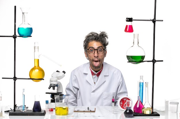 Front view crazy scientist in medical suit posing in funny manner on a white background virus lab chemistry covid