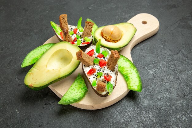 Front view creamy avocados with bread and pepper and fresh avocados on a grey space