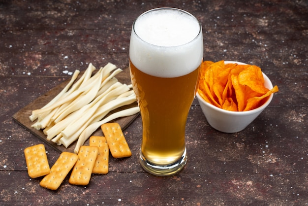 Front view of crisps and chips along with beer on the wooden desk