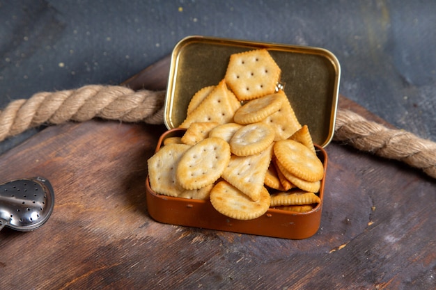 Front view of crisps and crackers on the wooden desk with ropes