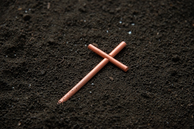 Free photo front view of cross on soil