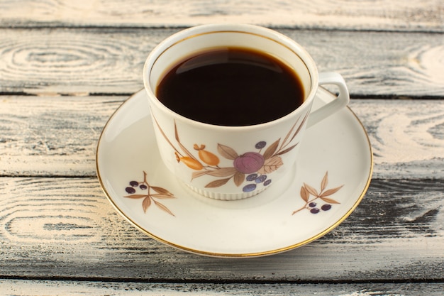 A front view cup of coffee hot and strong on the grey rustic desk coffee hot drink