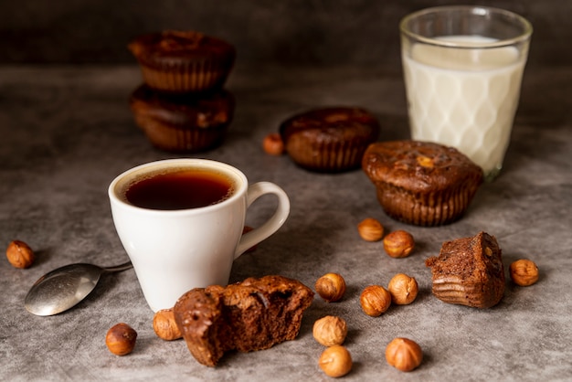 Free photo front view cup of coffee with muffins