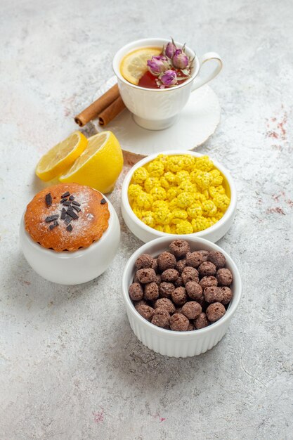 무료 사진 흰색 공간에 사탕과 레몬 조각과 차의 전면보기 컵