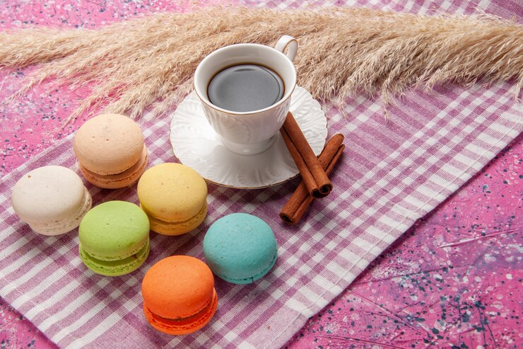 Free Photo front view cup of tea with cinnamon and french macarons on the pink desk cake biscuit cookie sweet sugar