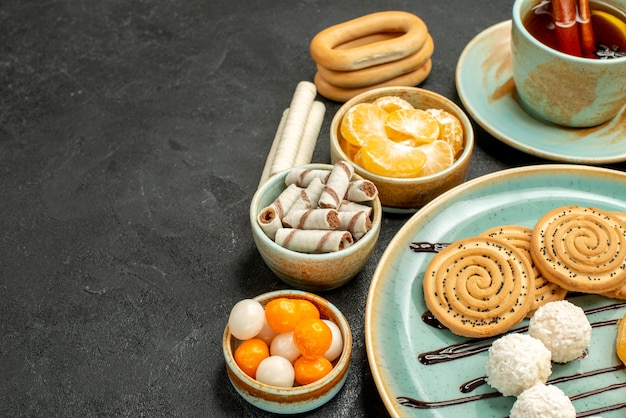 Free photo front view cup of tea with cookies and tangerines on grey desk cookie cake biscuit tea