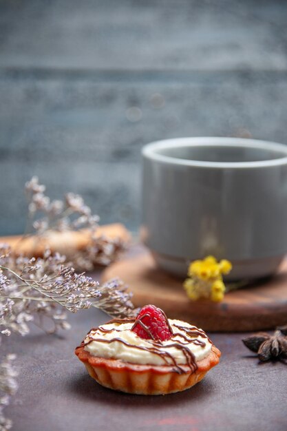 Вид спереди чашка чая с вкусным тортом на темном фоне чайный торт сладкий пирог печенье бисквит