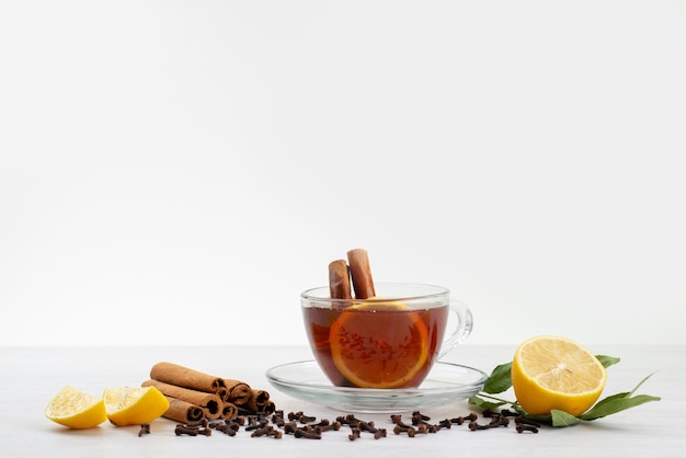 A front view cup of tea with lemon mint and cinnamon on white, tea dessert candy