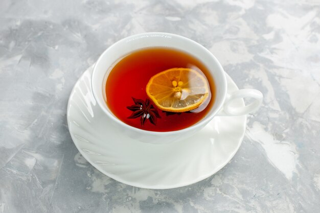 Front view cup of tea with lemon on white surface