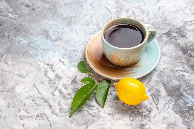 Вид спереди чашка чая с лимоном на белом столе фруктовый чайный напиток