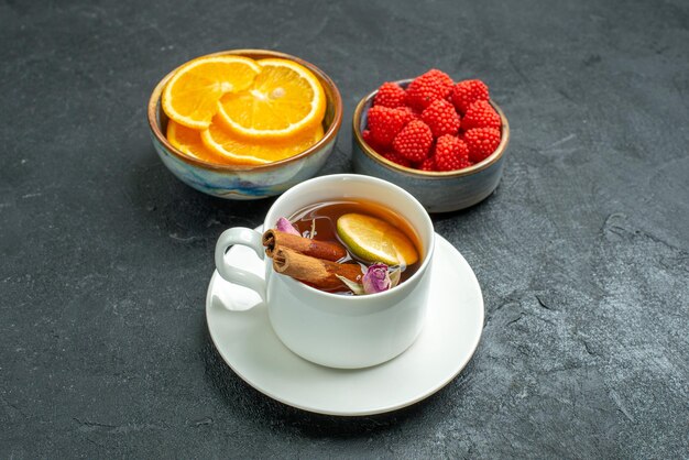 暗い表面のフルーツシトラスティーにオレンジスライスとコンフィチュールが付いた正面図のお茶