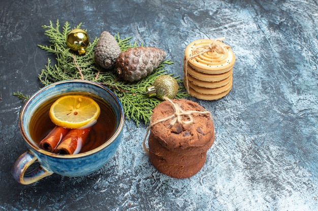 Front view cup of tea with sweet biscuits on light-dark background