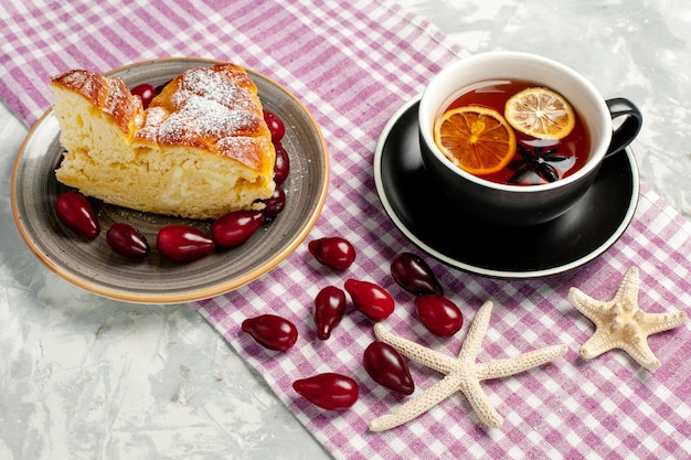 Front view cup of tea with yummy cake slice on a white surface