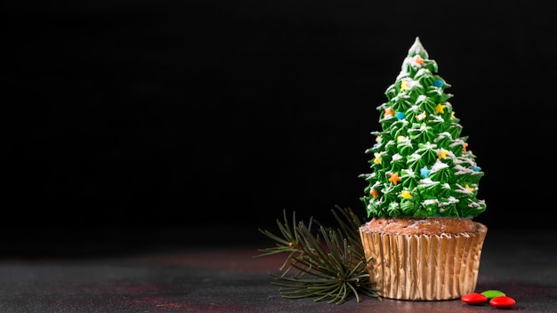 クリスマスツリーのフロスティングとコピースペースとカップケーキの正面図