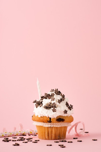 Free photo front view of cupcake with icing and candle