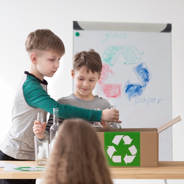 Front view cute children learning how to recycle