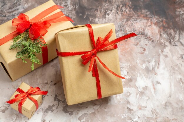 Front view cute christmas presents tied with red bows on light background