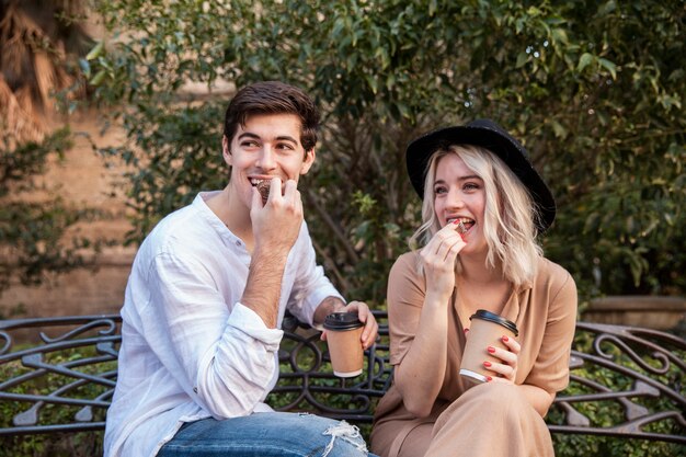 Front view of cute couple on bench at the park