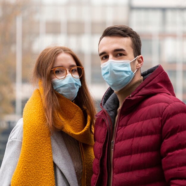 Front view of cute couple wearing medical masks