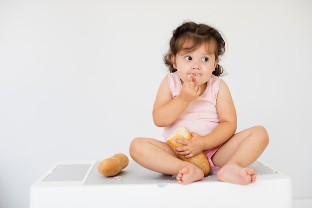 front view cute girl eating bread