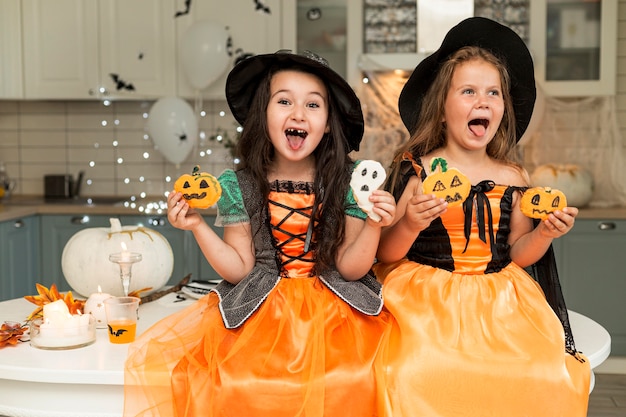 Free photo front view of cute girls with witch costume