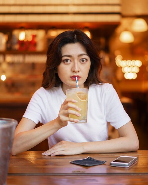 레모네이드를 마시는 귀여운 일본 여자의 전면보기