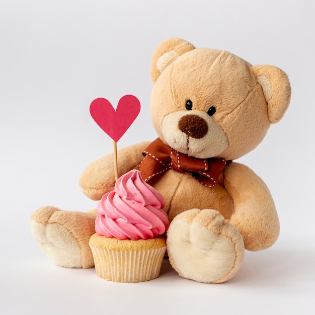 귀여운 작은 아기 소년 컵 케이크와 teddybear의 전면 모습