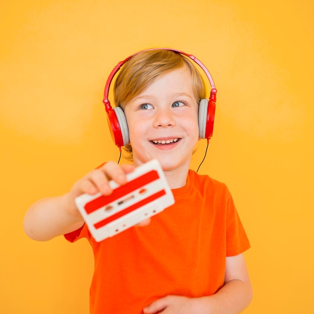 Front view of cute little boy listening to music