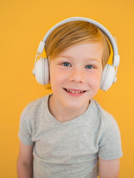 Free photo front view of cute little boy listening to music