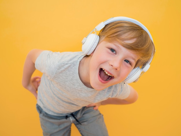 Front view of cute little boy listening to music