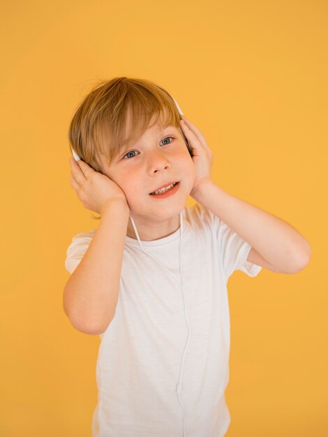 Front view of cute little boy listening to music