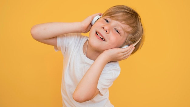 Front view of cute little boy listening to music