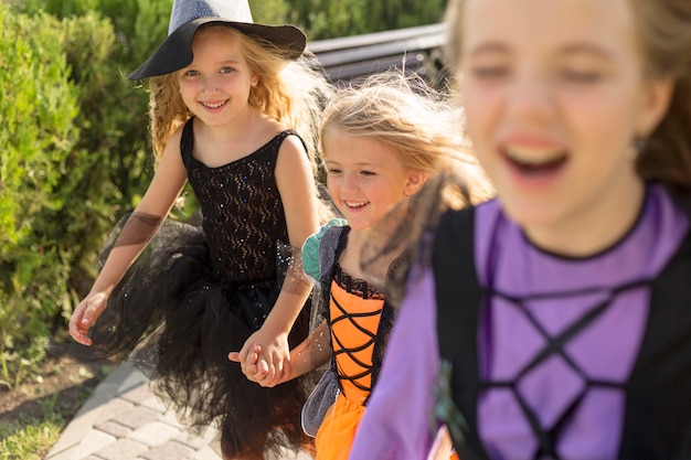 Front view of cute little girls with halloween costumes