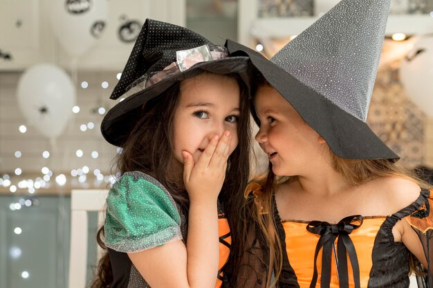 Front view of cute little girls with witch costume