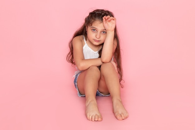 A front view cute little kid sitting with stressed expression