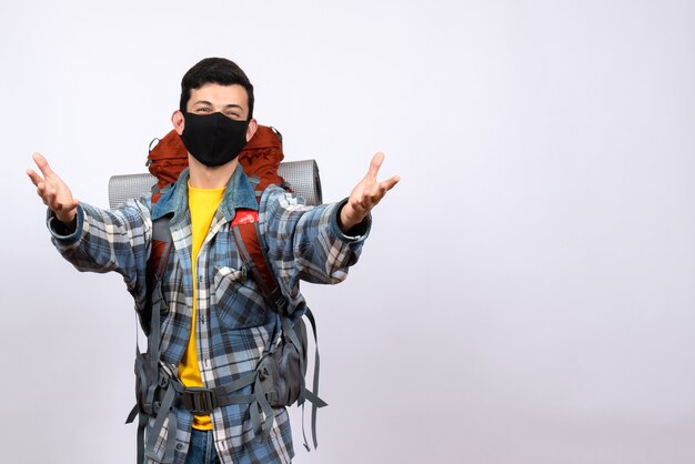 Front view cute male traveler with backpack and mask opening hands to hug