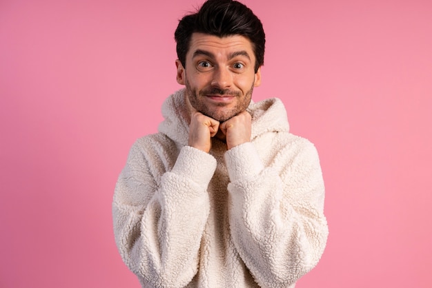 Front view of cute man posing with his hands under his chin