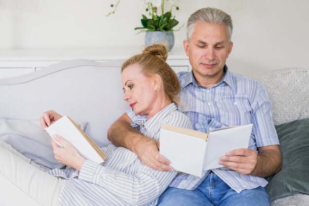 Front view cute senior couple reading books