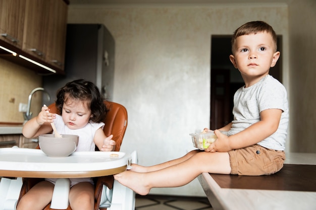 Front view cute siblings in the kitchen