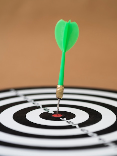 Front view of dart board with dart on bull's-eye