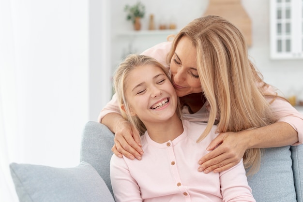 Free photo front view daughter kissed by her mother