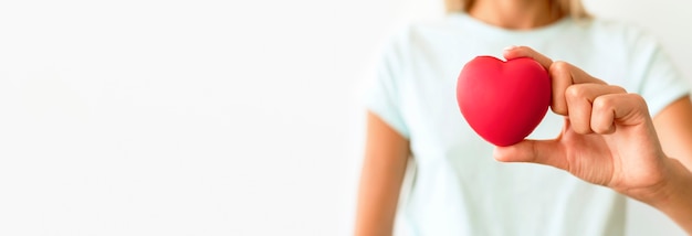 Front view of defocused woman holding heart shape
