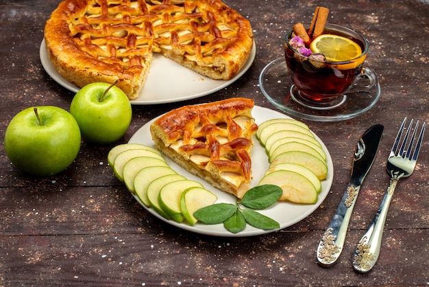 Free photo a front view delicious apple cake with tea fresh green apples on the wooden desk cake biscuit sugar