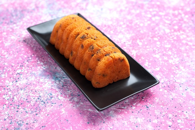 Front view delicious baked cake inside black cake pan on pink desk.