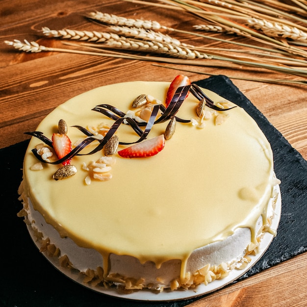 Вид спереди вкусный торт ко дню рождения украшен вкусный круглый внутри белой тарелке сладкое печенье на день рождения на коричневом фоне
