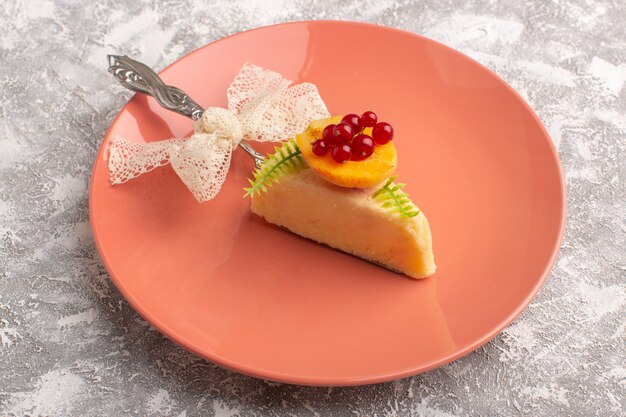 Front view of delicious cake slice with apricot inside peach plate on the light surface