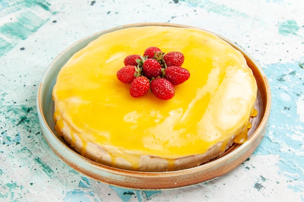 Front view delicious cake with yellow syrup and red strawberries on blue desk